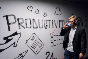 A man looking at graffiti that says "Productivity" entailing efficiency in their workplace.